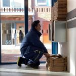 Medarbetare fyller på med matavfallspåsar i miljöhuset