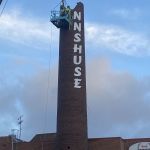 Rivning av den höga skortsenen i Brunnsbo. Halva skorstenen är riven.