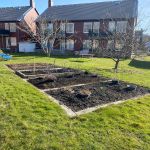 Odlingslotter framför hus i Amhult.